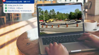 Construction café event info shown beside laptop displaying MR117 road construction scene in Baysville.