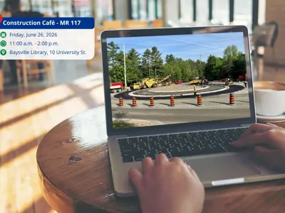 Construction café event info shown beside laptop displaying MR117 road construction scene in Baysville.