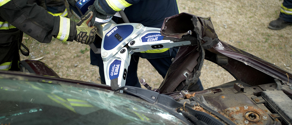 A HURST Jaws of Life SP 555 E3 Spreader being used on a car in a training exercise