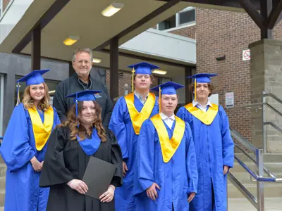 Mayor Terry Glover stands with five high school graduates