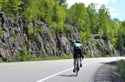 Cycler on road with a rock cut